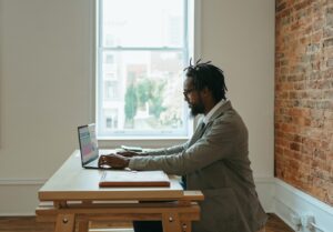 a person sitting at a desk with a laptop and papers