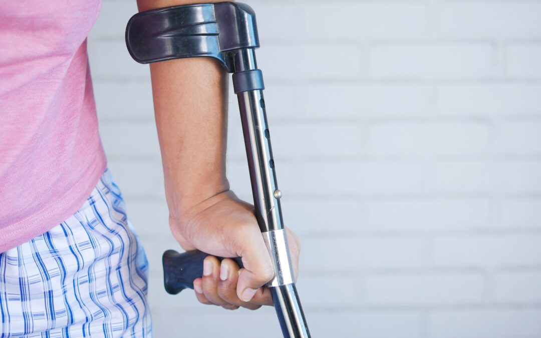 a person holding a crutch and walking cane