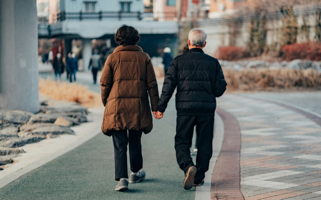 man in brown jacket and gray pants walking on sidewalk during daytime